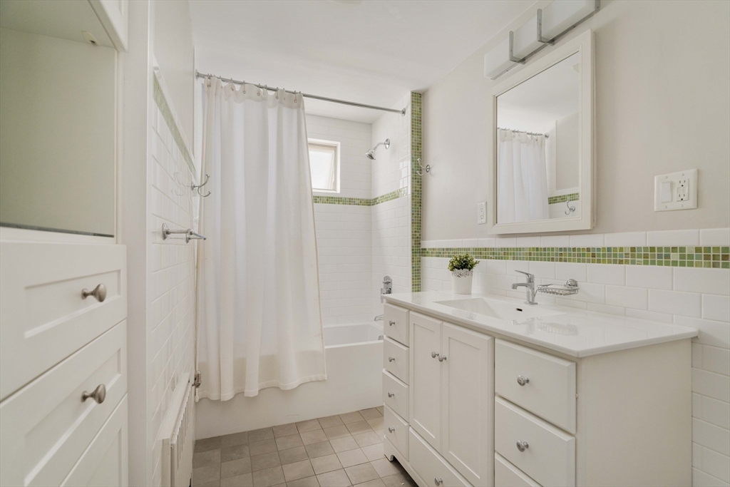 59 Pemberton Street, Unit 1 Cambridge, MA 02140 - Photo 22 of 30 a bathroom with a sink a mirror a vanity and a shower