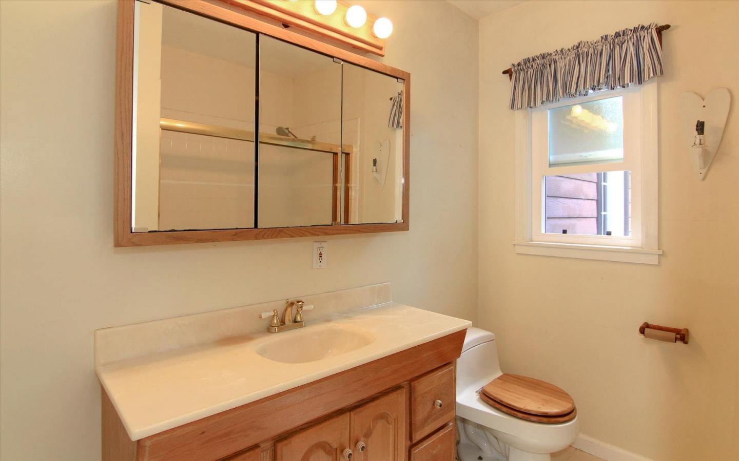 1251 Pacific Street Monterey, CA 93940 - Photo 13 of 25 a bathroom with a sink a toilet and a mirror