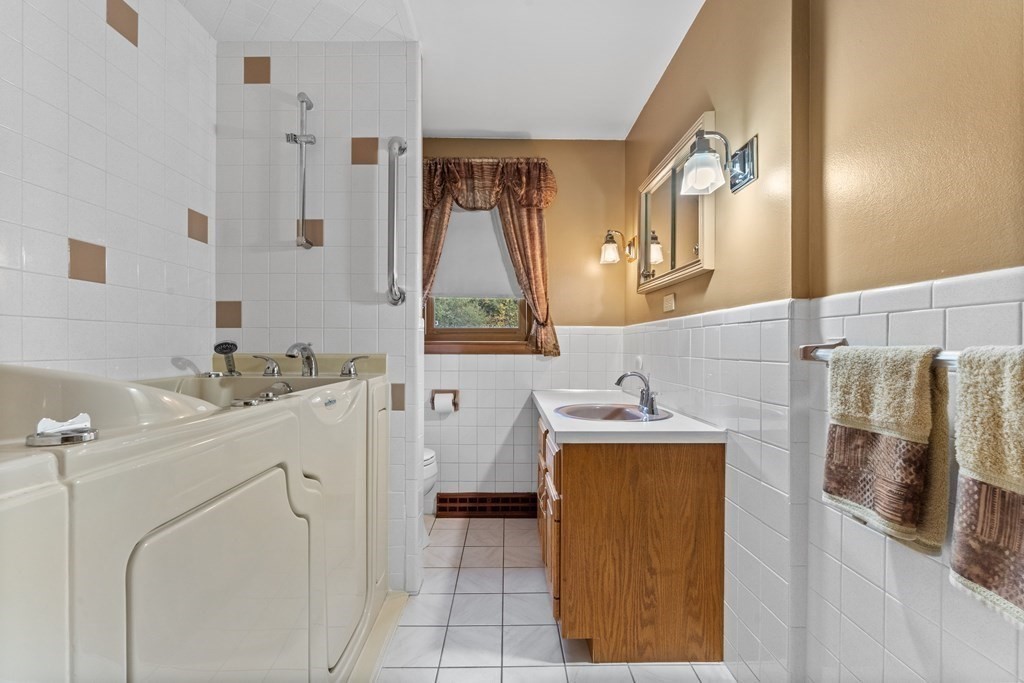 135 Rustic Road Walpole, MA 02032 - Photo 16 of 37 a bathroom with a sink a mirror and a bathtub