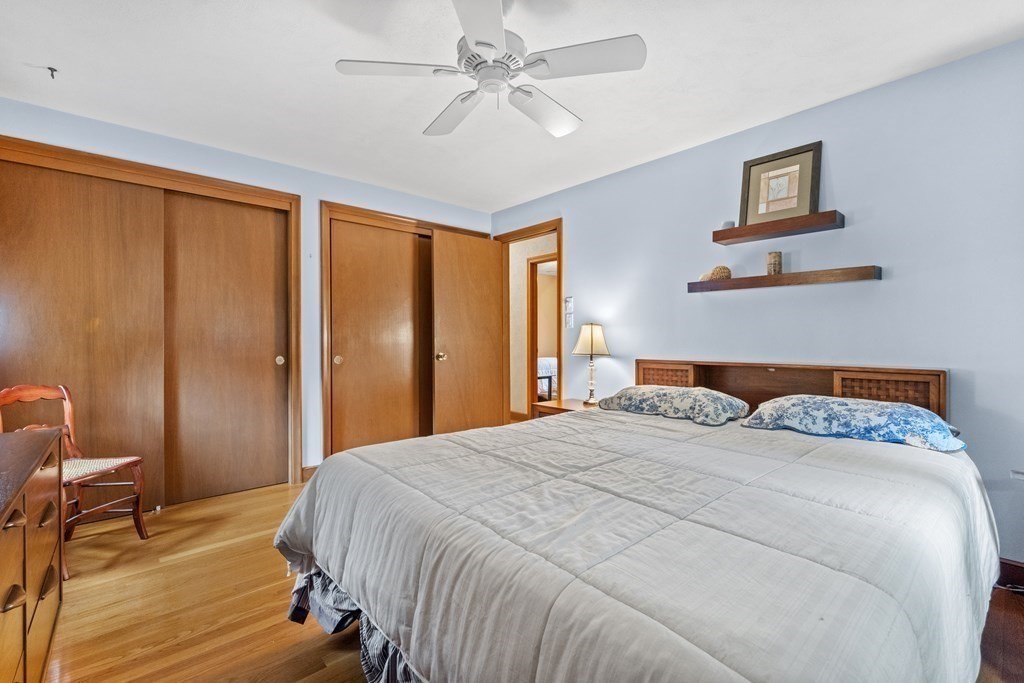 135 Rustic Road Walpole, MA 02032 - Photo 24 of 37 a bedroom with a large bed and a chandelier