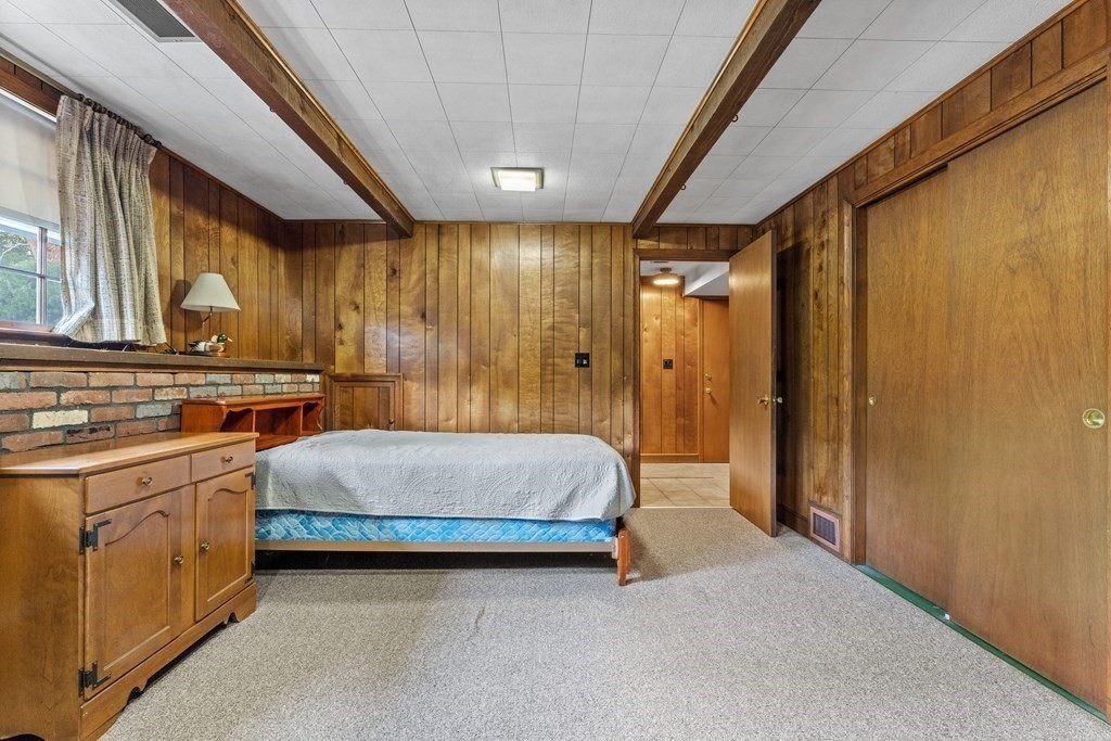 135 Rustic Road Walpole, MA 02032 - Photo 26 of 37 a spacious bedroom with a bed and a chandelier