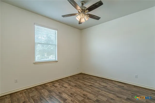 an empty room with a window and a fan