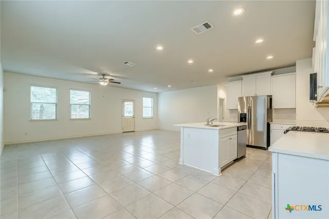 a large kitchen with a large counter top stainless steel appliances and cabinets