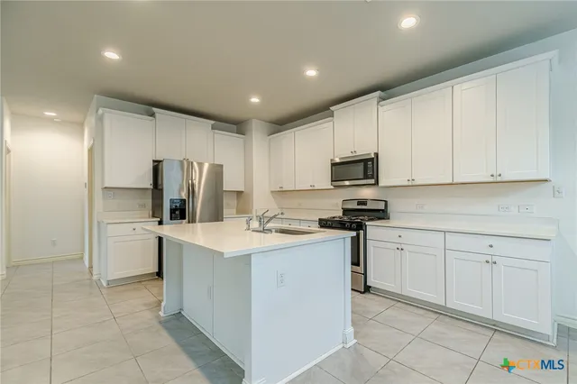 a kitchen with a sink a stove a refrigerator and cabinets