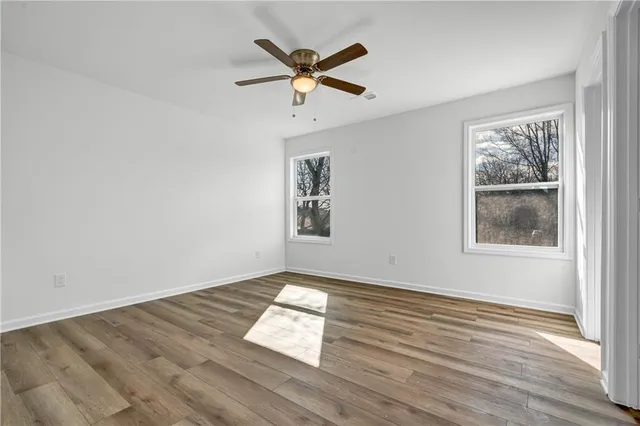 a view of wooden floor and a chandelier fan in a room