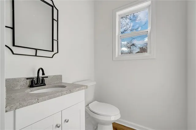 a bathroom with a toilet sink vanity and mirror
