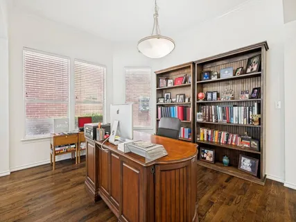a view of a workspace with furniture and a book shelf