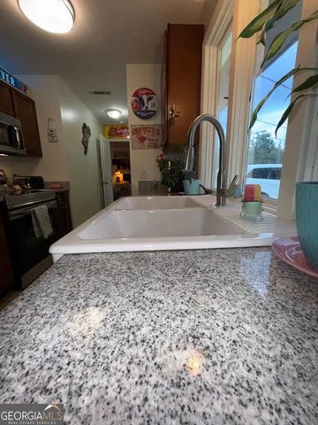 a kitchen with a stove a sink and a microwave