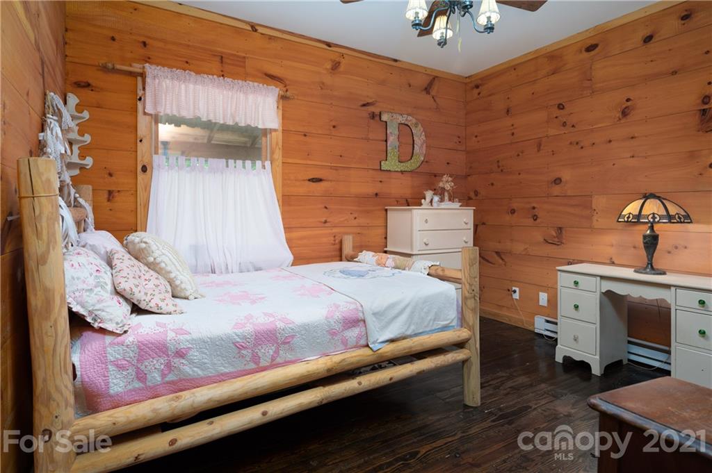 84 Blossom Road Brevard, NC 28712 - Photo 12 of 19 a bedroom with a bed and a chandelier