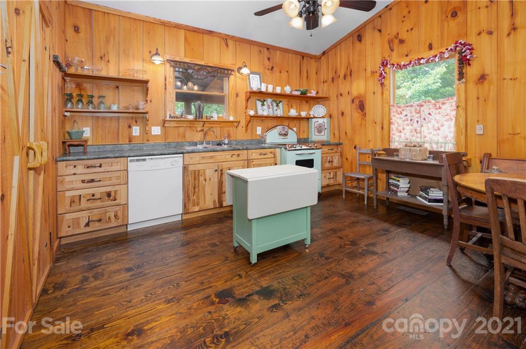 84 Blossom Road Brevard, NC 28712 - Photo 4 of 19 a living room with furniture a dining table wooden floor and a floor to ceiling window