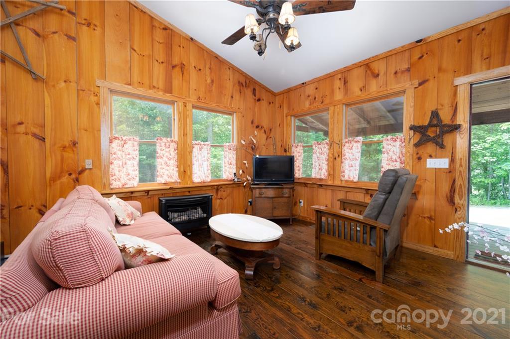 84 Blossom Road Brevard, NC 28712 - Photo 5 of 19 a living room with furniture a fireplace and a floor to ceiling window