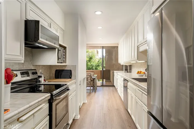 a kitchen with stainless steel appliances a stove sink microwave and cabinets