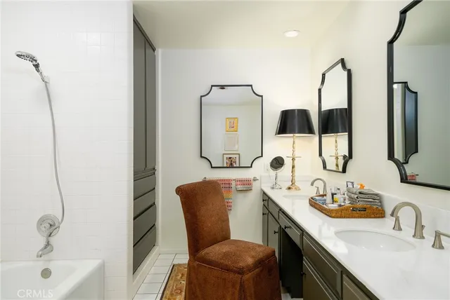 a bathroom with a granite countertop sink mirror and tub