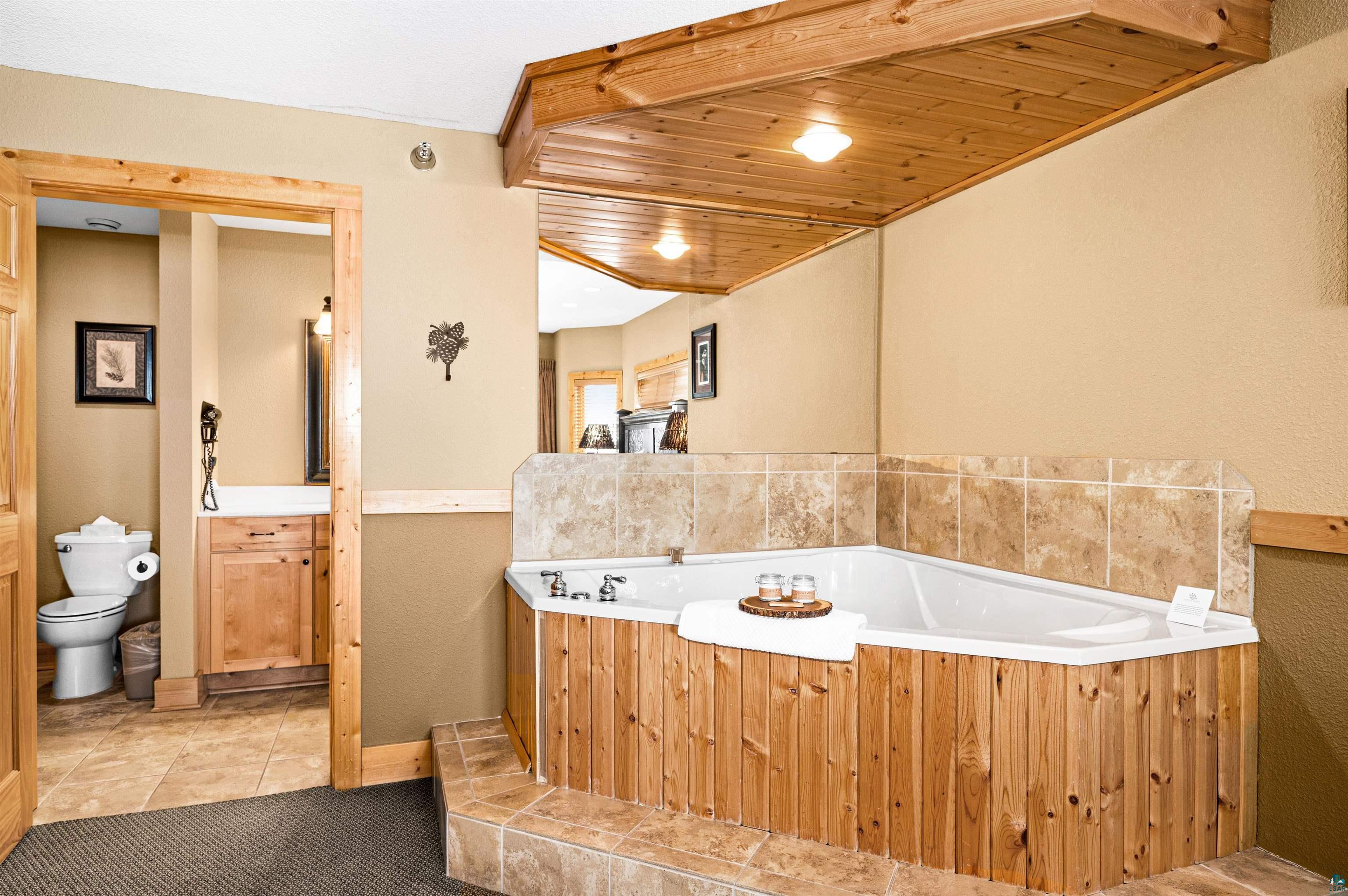Two Burlington Road, Unit 5404 Two Harbors, MN 55616 - Photo 11 of 27 Full bath featuring tile patterned floors, a garden tub, wooden ceiling, and toilet
