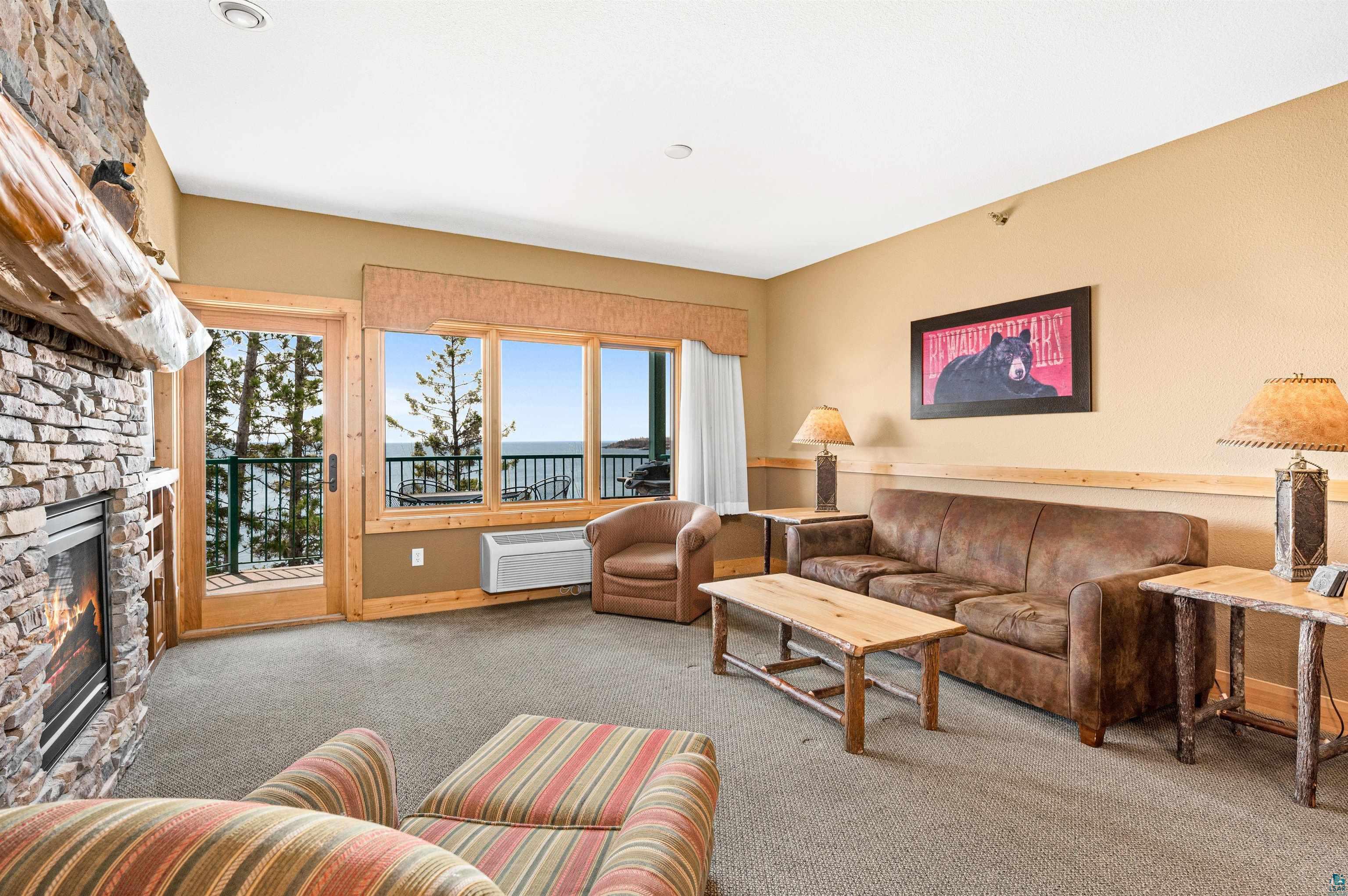 Two Burlington Road, Unit 5404 Two Harbors, MN 55616 - Photo 14 of 27 Carpeted living room with a fireplace and a wall mounted AC