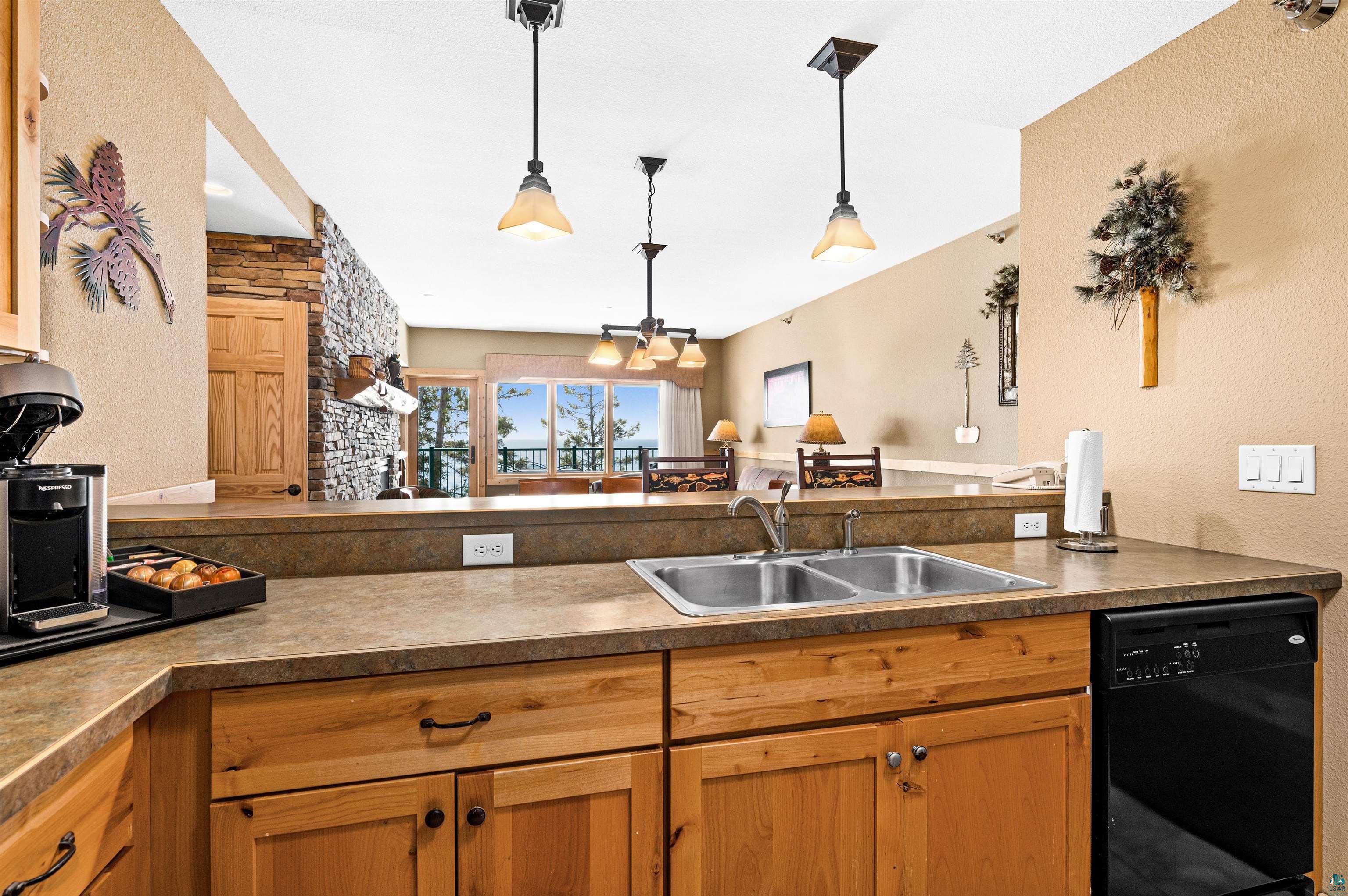 Two Burlington Road, Unit 5404 Two Harbors, MN 55616 - Photo 17 of 27 Kitchen featuring dark countertops, dishwasher, pendant lighting, and a sink
