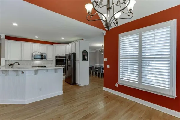 a large kitchen with stainless steel appliances kitchen island granite countertop a sink and cabinets