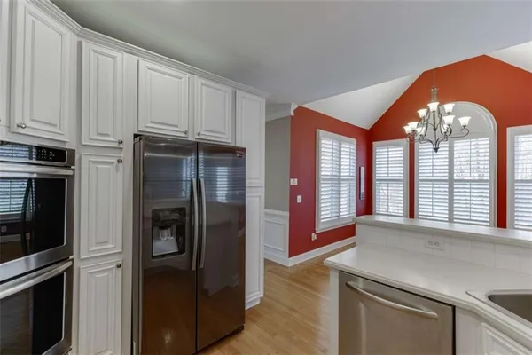 a living room with furniture a flat screen tv and kitchen view