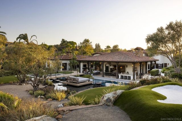 a view of a house with swimming pool and chairs