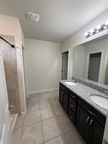 a bathroom with a granite countertop sink and shower