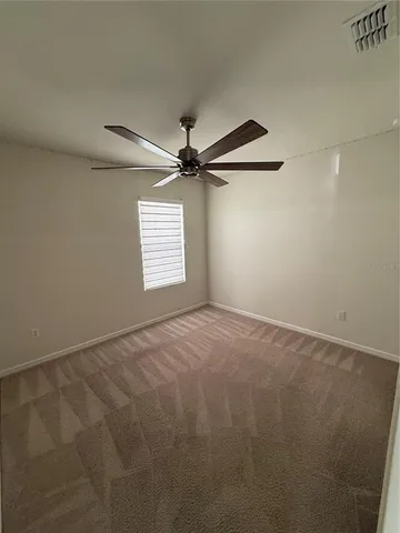 a view of a big room with a ceiling fan and windows