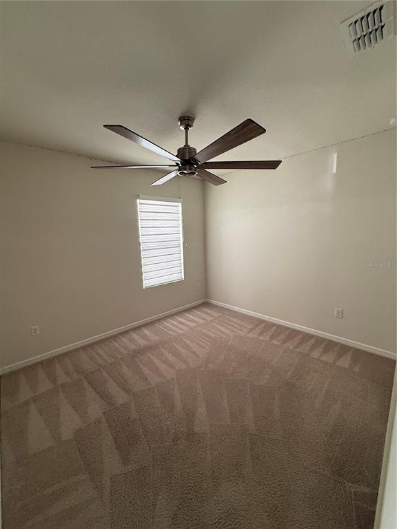 619 Citrus Isle Boulevard Davenport, FL 33837 - Photo 7 of 21 a view of a big room with a ceiling fan and windows