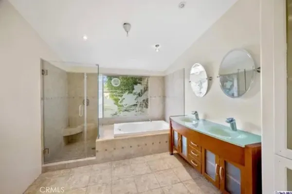a spacious bathroom with a tub sink and mirror