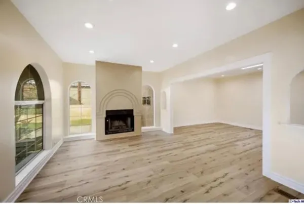 a view of an empty room with a fireplace and a window