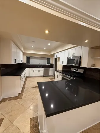 a large kitchen with stainless steel appliances and a counter top space