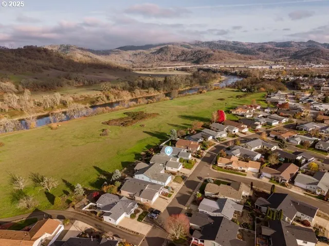 an aerial view of ocean and residential houses with outdoor space