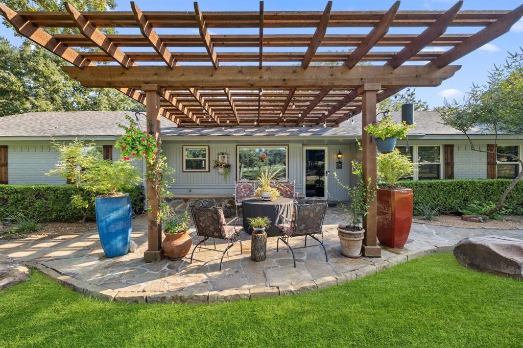 635 Old Justin Road Argyle, TX 76226 - Photo 2 of 36 a view of a patio with table and chairs potted plants and large tree