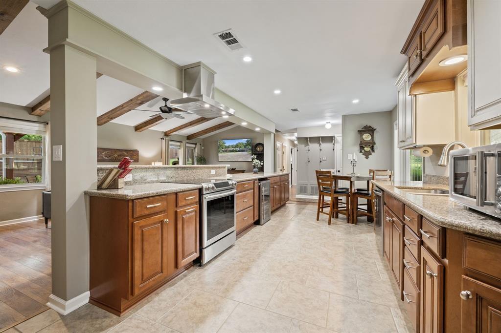 635 Old Justin Road Argyle, TX 76226 - Photo 5 of 36 a kitchen with stainless steel appliances kitchen island granite countertop a stove a sink a dining table and chairs