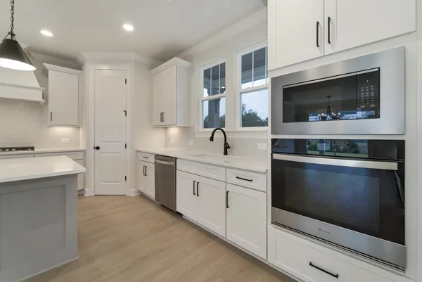 a kitchen with stainless steel appliances granite countertop a sink a stove and a refrigerator