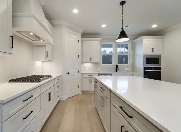 a kitchen with white cabinets and appliances