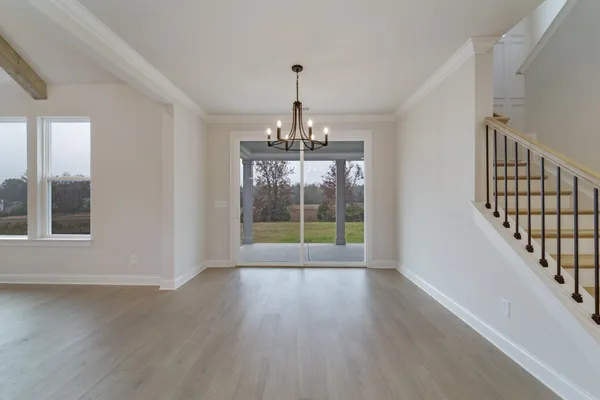 a view of an empty room with wooden floor fan