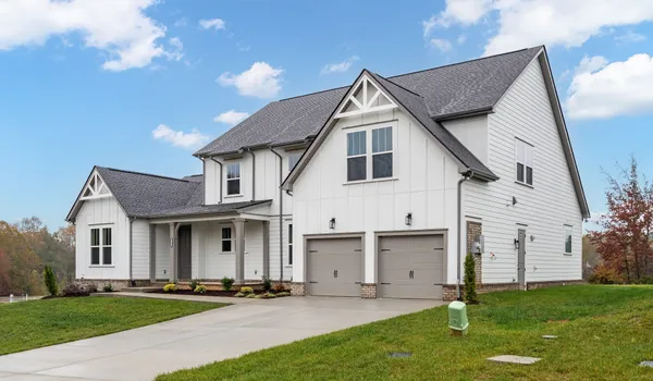 a front view of a house with a garden and yard