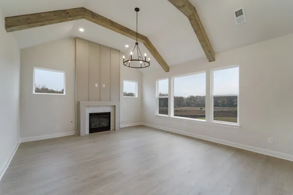 an empty room with windows and fireplace