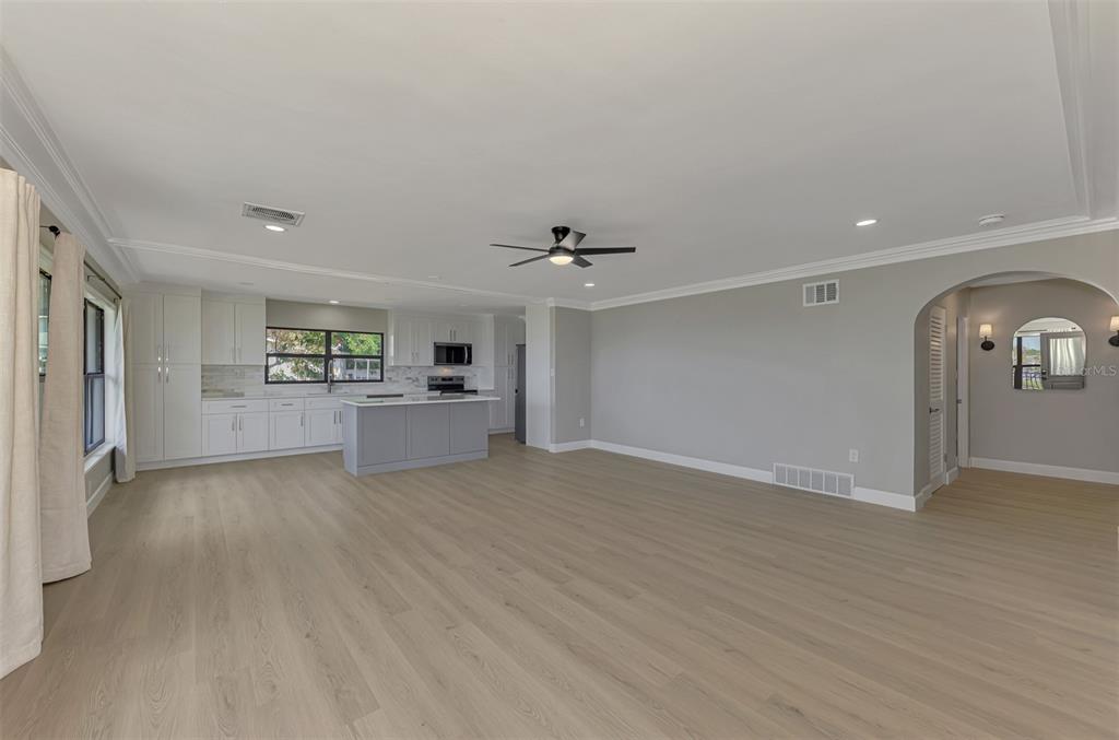 1822 Riverside Drive East Bradenton, FL 34208 - Photo 10 of 46 wooden floor in an empty room with a cabinet and a kitchen