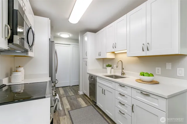 a kitchen with stainless steel appliances granite countertop a sink stove and refrigerator