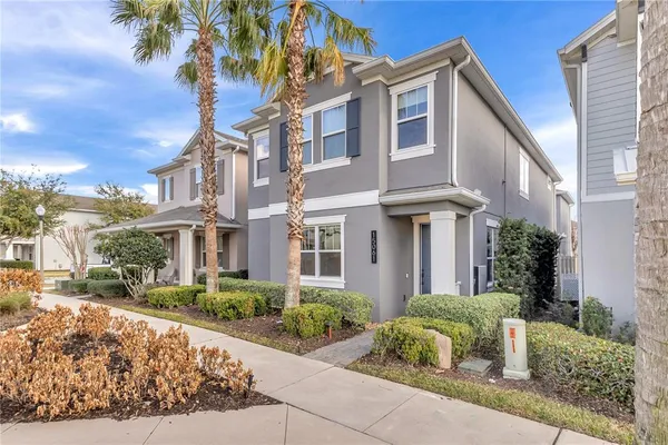 a front view of a multi story residential apartment building with yard and car parked