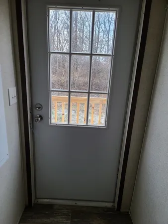 a view of a small space with wooden floor and a window
