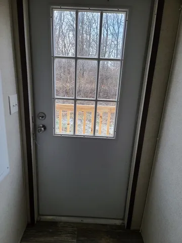 a view of a small space with wooden floor and a window