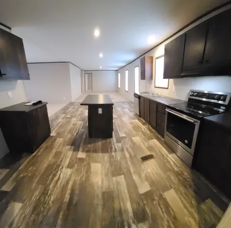a kitchen with granite countertop a stove top oven and cabinets