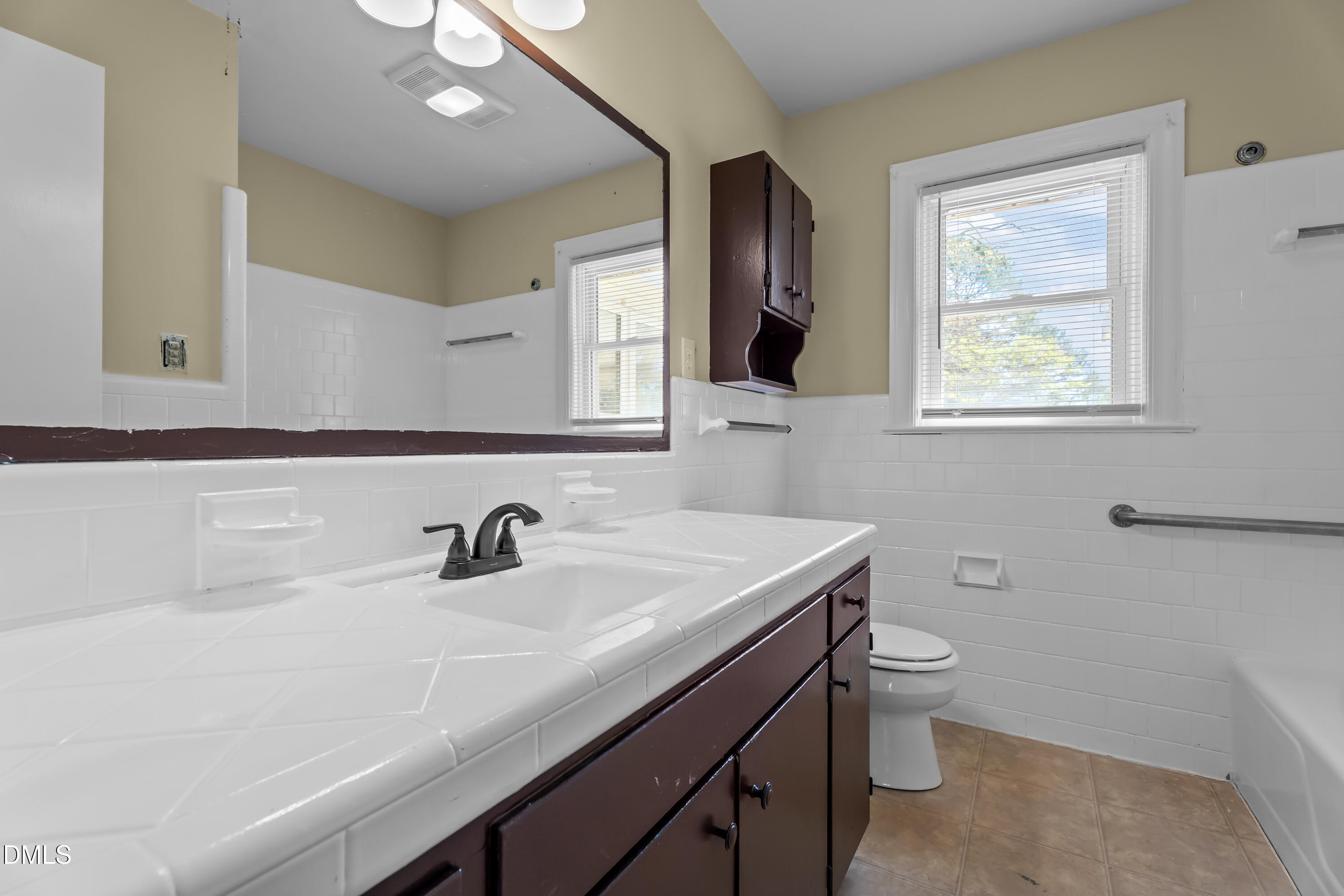 4149 Woodcrest Road Rocky Mount, NC 27803 - Photo 35 of 43 a bathroom with a sink a toilet and a mirror