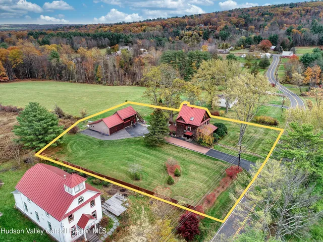 a view of a house with a big yard plants and large trees
