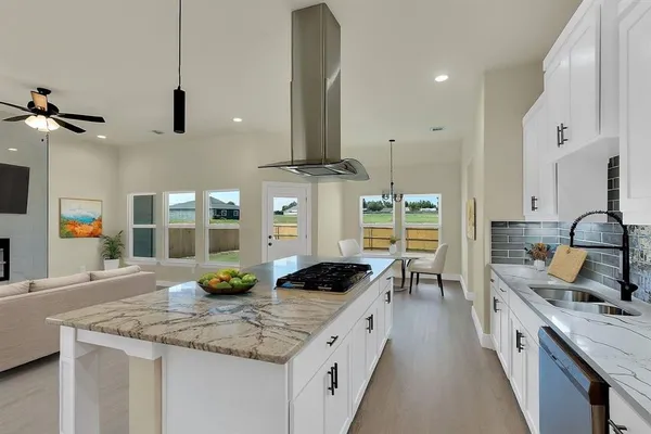 a kitchen with stainless steel appliances granite countertop a sink a stove and a wooden floors
