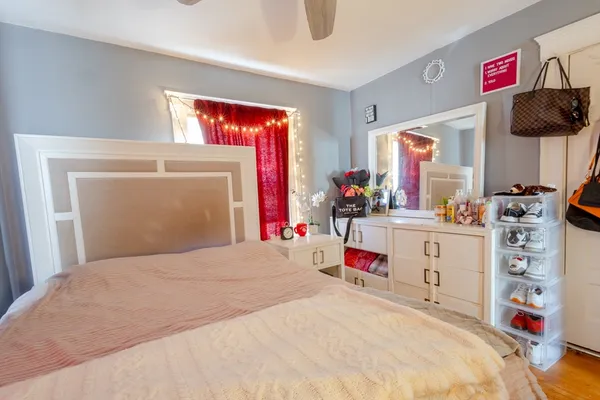 a bedroom with a bed a window and dresser