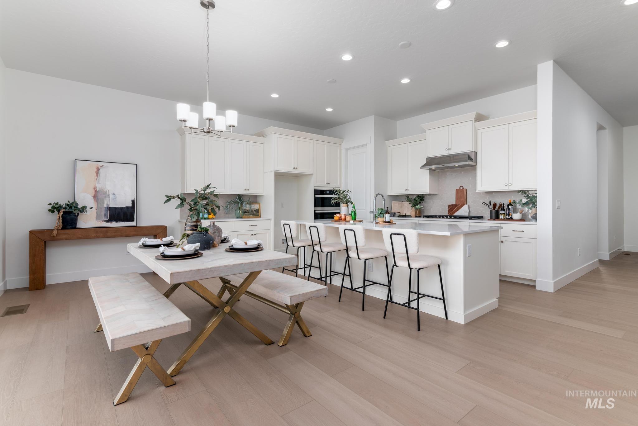 8501 South Country Wind Avenue Meridian, ID 83642 - Photo 9 of 39 Spacious kitchen and dining area featuring light wood-finish flooring, recessed lighting, and a contemporary chandelier