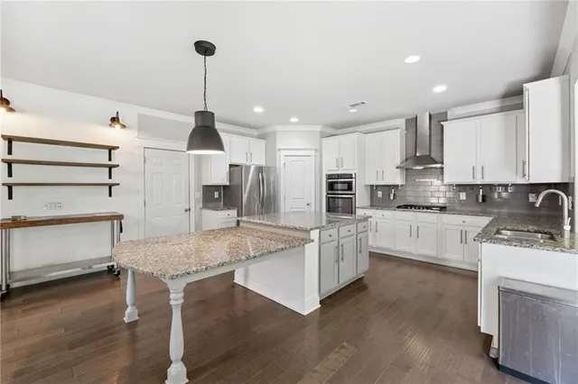 a kitchen with stainless steel appliances kitchen island granite countertop a stove and a sink