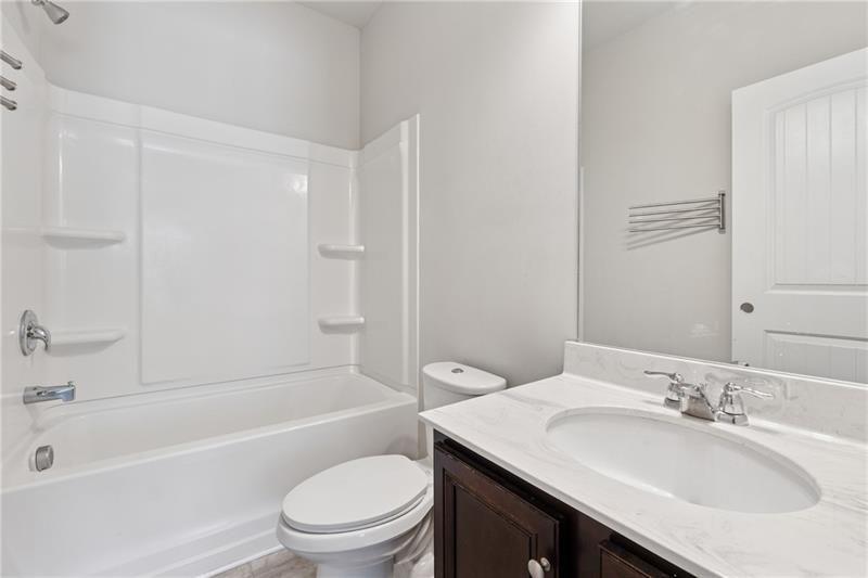 108 Madison Street Canton, GA 30115 - Photo 24 of 43 a bathroom with a granite countertop sink toilet a mirror and bathtub